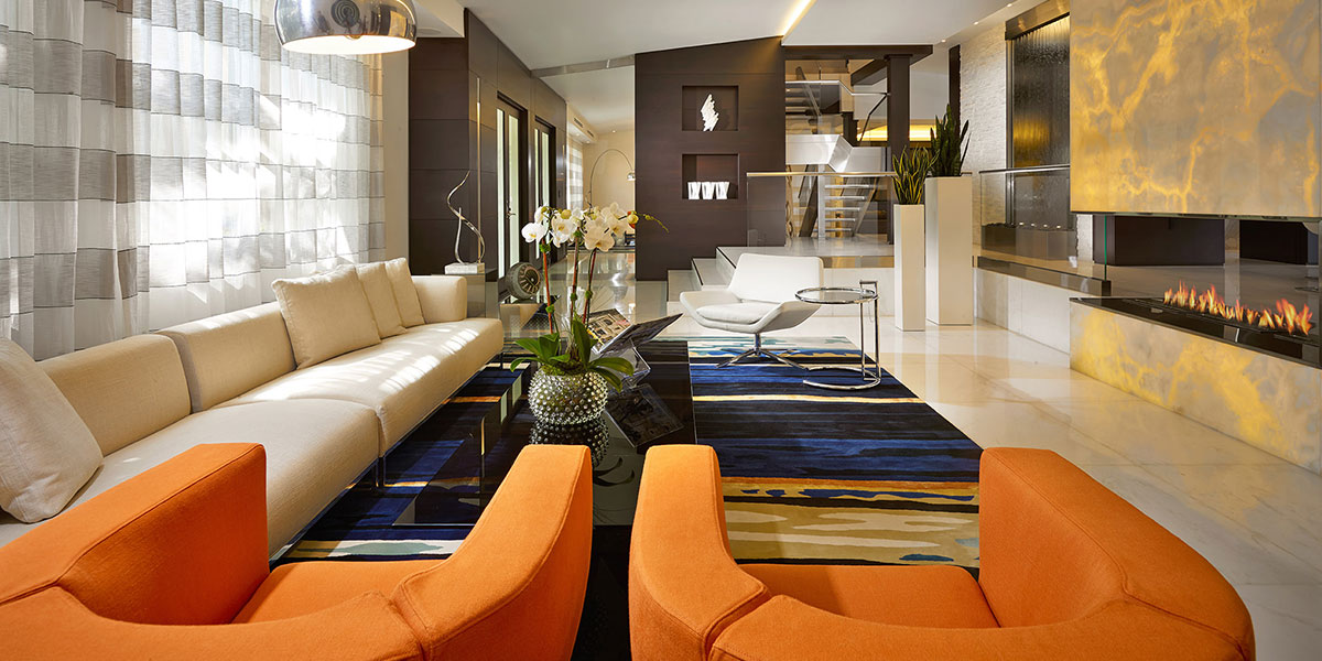 Luxurious Living Room With Modern White Sofa, Orange Armchairs And Beautiful Fireplace