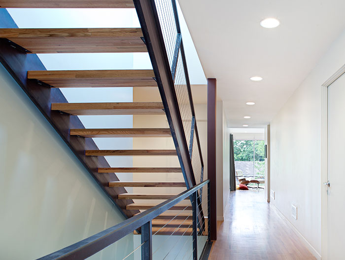 Steel Staircase Connecting The Top Levels Of The House To The Open-Plan Kitchen And Living Area