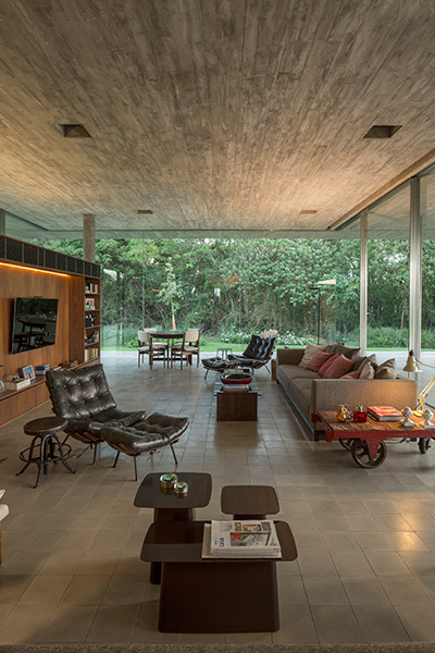 Beautiful living area in a minimalist Brazilian house by Studio MK 27 that appears to float above the ground