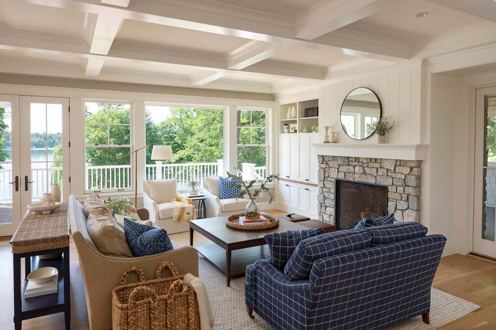 Bright living room with lakeside views, shiplap stone fireplace and mirror above fireplace