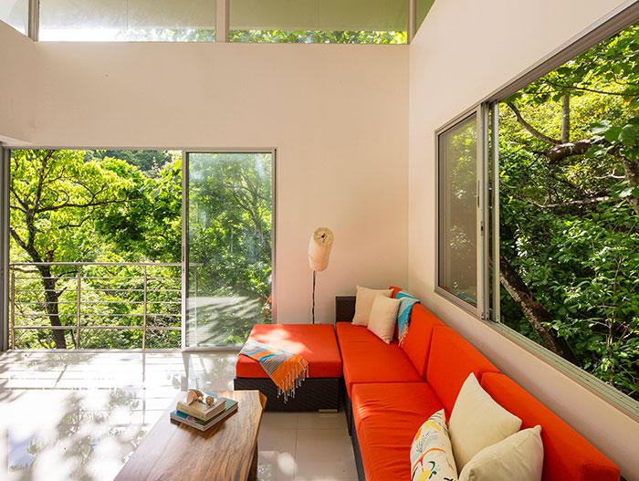 Seagull House by Indigo Arquitectura: Colorful living room design idea in amazing suspended house in Costa Rica that blends with the dense forest