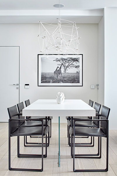 Beautiful dining table and contemporary lighting fixture in comfortable and sophisticated apartment by Alexandra Fedorova Architectural Bureau