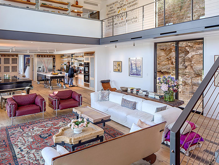 Eclectic interior design of living room in cliff dwelling by Specht Architects