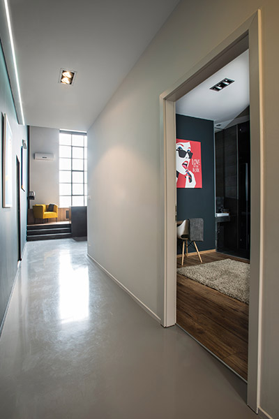 Great hallway leading to colorful yellow furniture piece in great living room, while on the side a colorful art piece can be found in the master bedroom - apartment Budapest