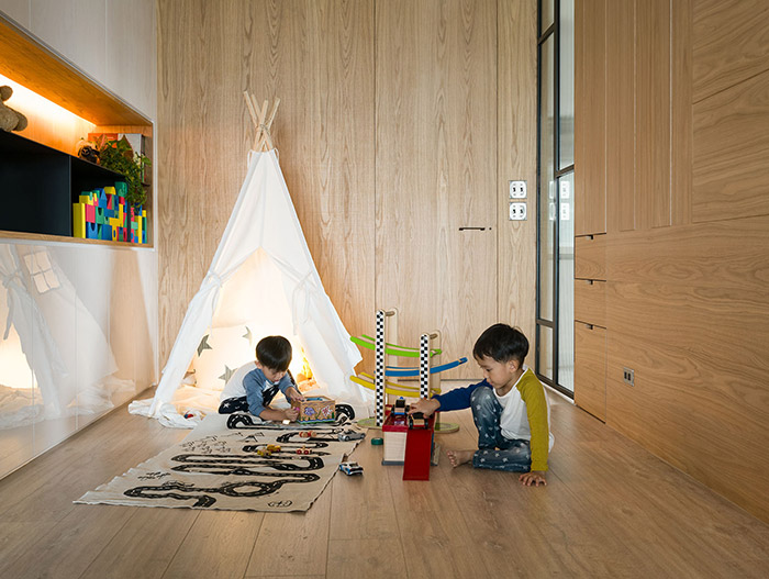 Play space with a teepee and plenty of toys  for kids in an inviting apartment by Awork Design Studio