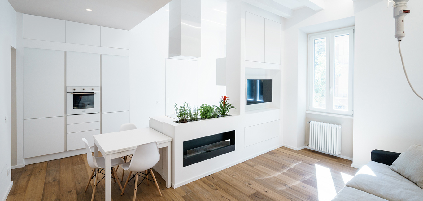 Modern kitchen design idea with multifunctional wall in an all-white minimalist apartment in Rome, Italy by Brain Factory - Architecture & Design