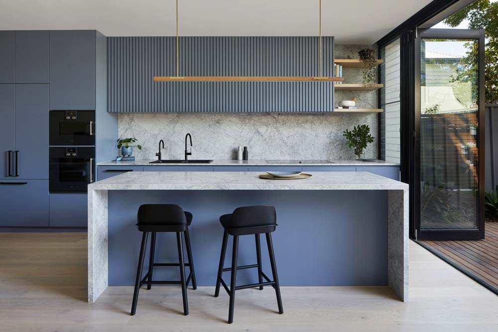 Contemporary kitchen with light blue cabinets, white marble kitchen island, marble countertops and backsplash