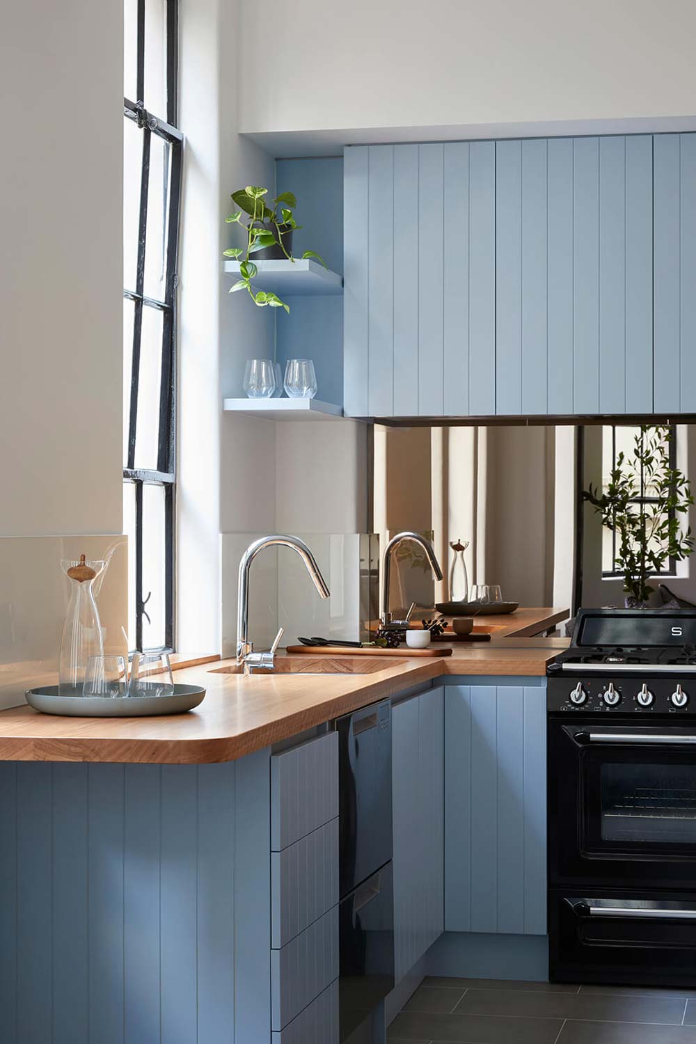 Bright kitchen with light blue cabinets and wooden countertops