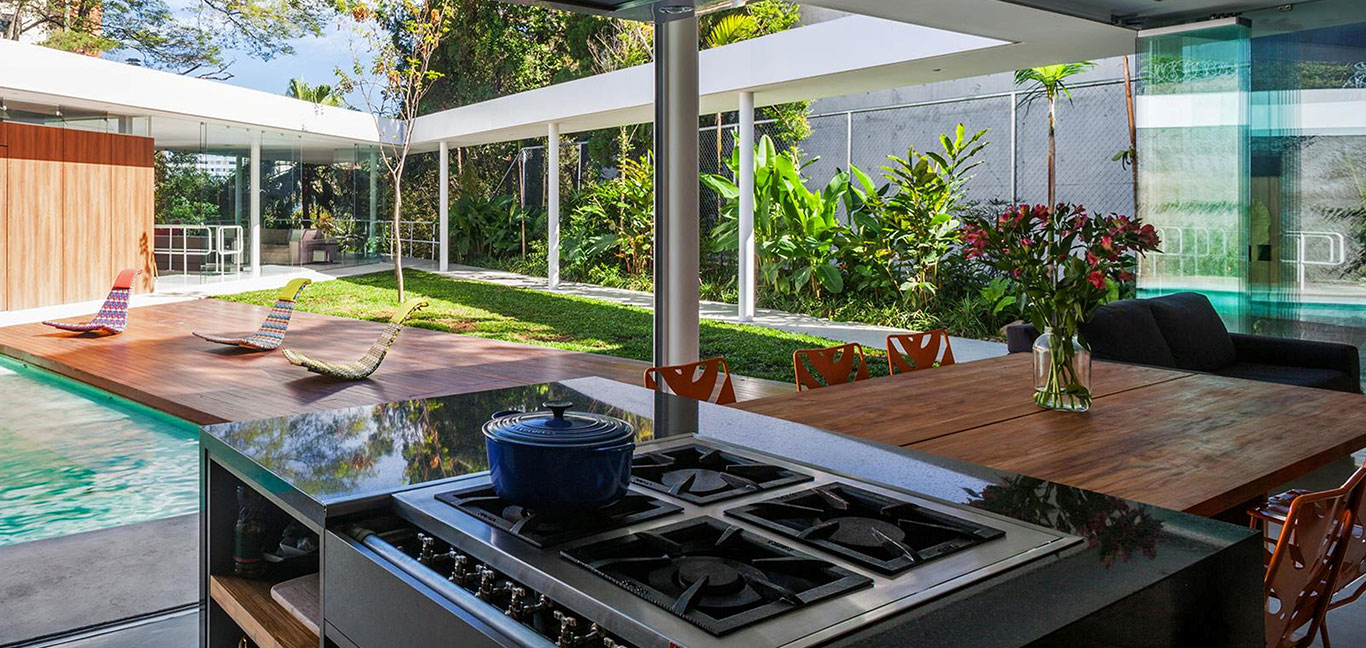 Modern kitchen overlooking patio and swimming pool in incredible house in Sao Paulo Brazil by FGMF Architects