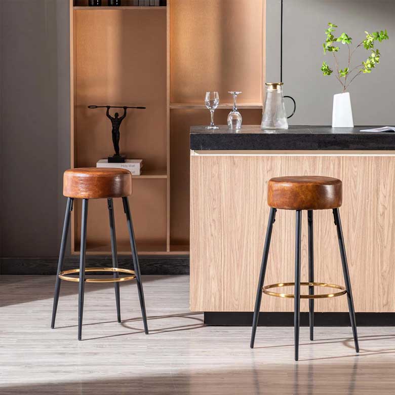 Leather bar stools with round seats and flared black metal legs