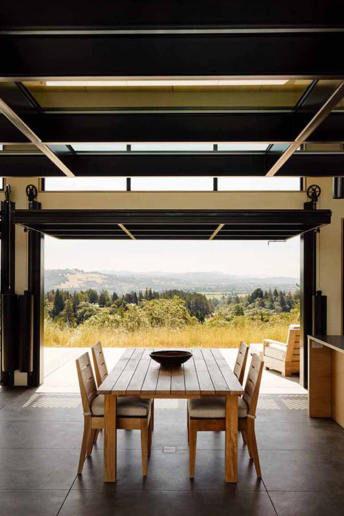 Amazing dining room opens to spectacular California wine country surroundings through massive glass walls - designed by Feldman Architecture