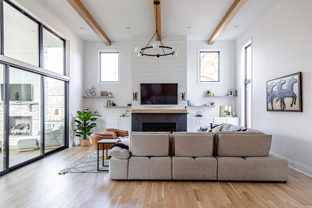Modern Farmhouse Living Room With Shiplap Fireplace Wall, Exposed Ceiling Beams And Wall-Mounted TV