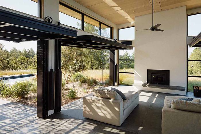 Modern living room design idea - massive glass walls connect interior to spectacular Californian wine country surroundings