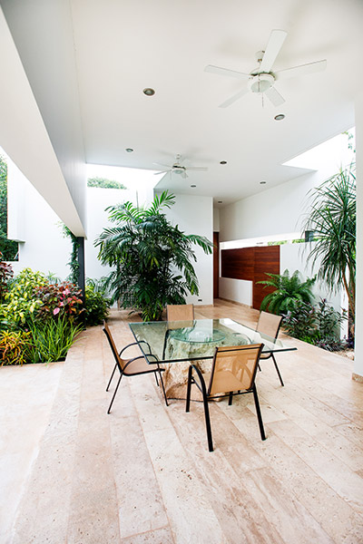 Amazing outdoor lounge area overlooks large living room, swing chair and lush garden - designed by Seijo Peon Architects