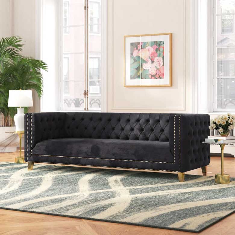 Rectangular black velvet couch with nailhead trim, button-tufting and tapered metal legs