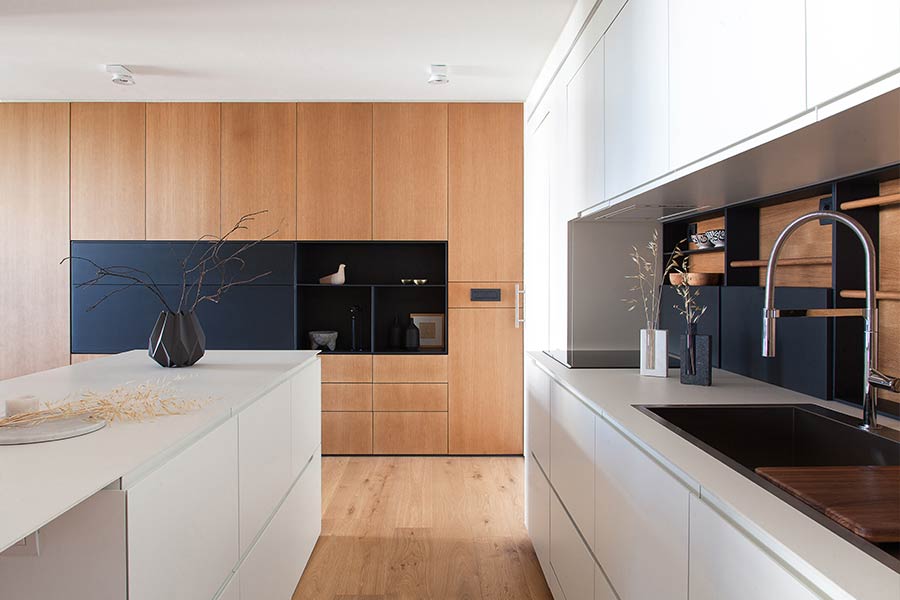 Modern, white kitchen with large floor-to-ceiling cabinetry in a renovated apartment in Barcelona
