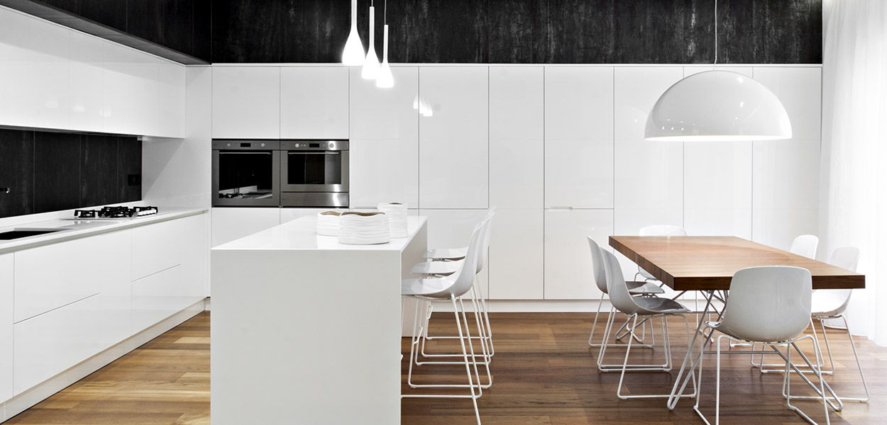 Renovated apartment in Italy by M12 Architettura Design: the kitchen has an elegant black and white palette and custom cabinets