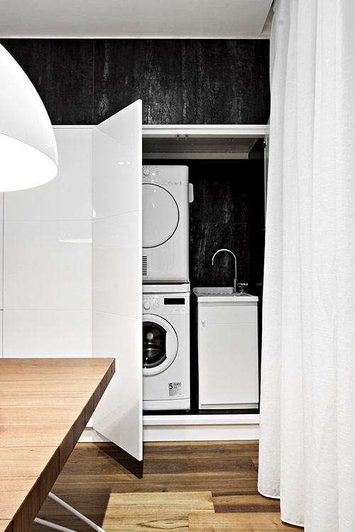 Modern kitchen with custom cabinets to hide the washing machine - renovated apartment in Italy