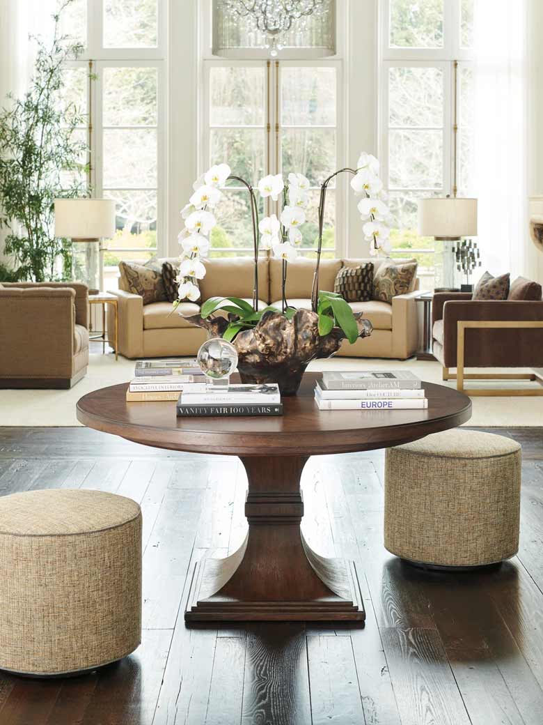 This round dining table extends to accommodate six people; it features walnut veneer pattern on the top and a flared pedestal base