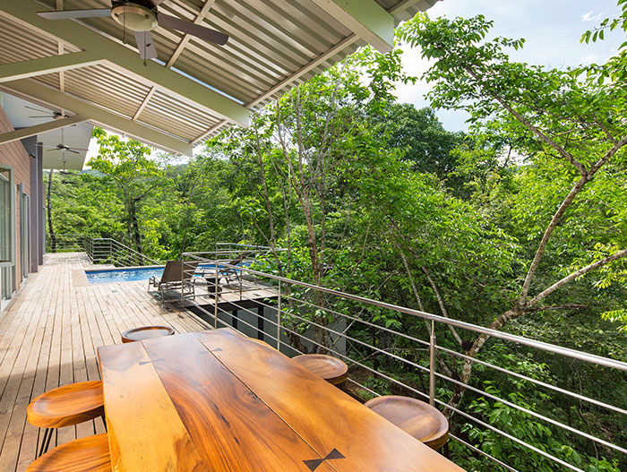 Relaxing terrace of a suspended Costa Rican house that blends with the dense forest - by Indigo Arquitectura