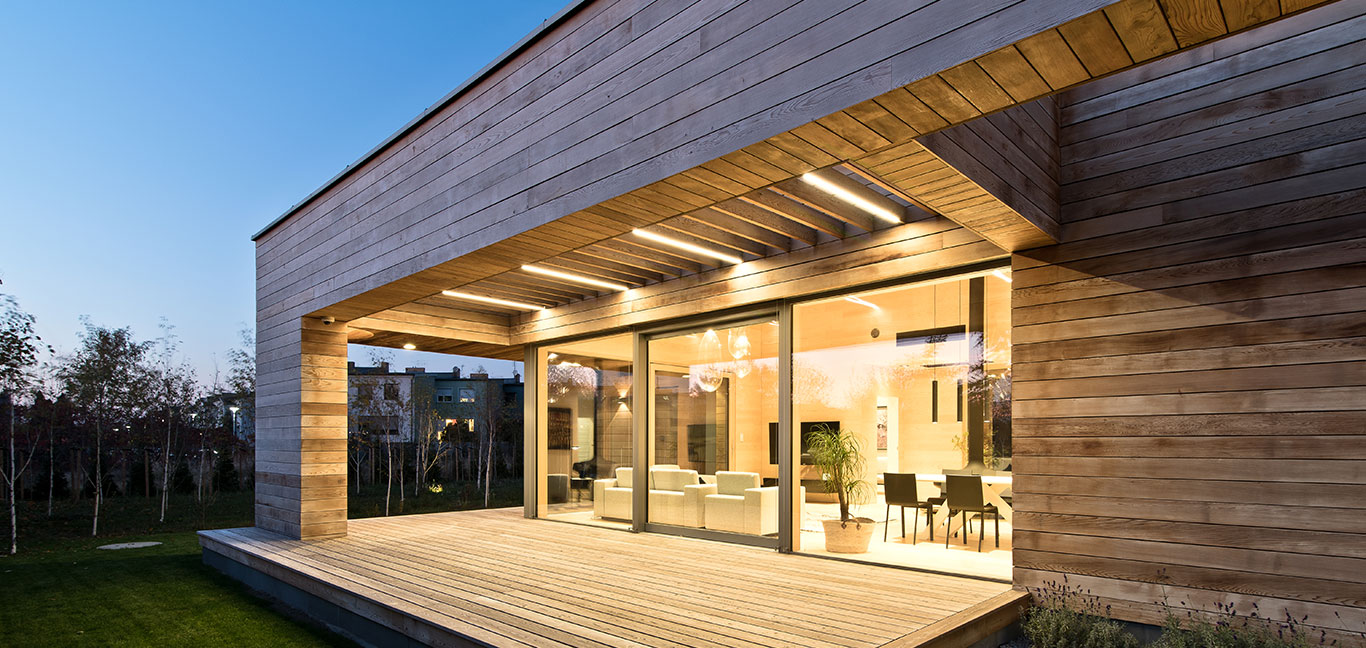 Single-storey house in Poznan, Poland is almost entirely clad in cedar planks and features big glazing for seamless indoor-outdoor transition