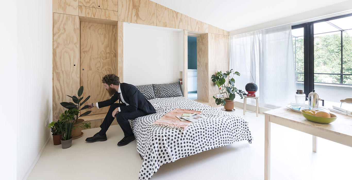 Small 28 square meter apartment in Milan gets modern remodeling which includes a multifunctional furniture piece that hides floating double bed