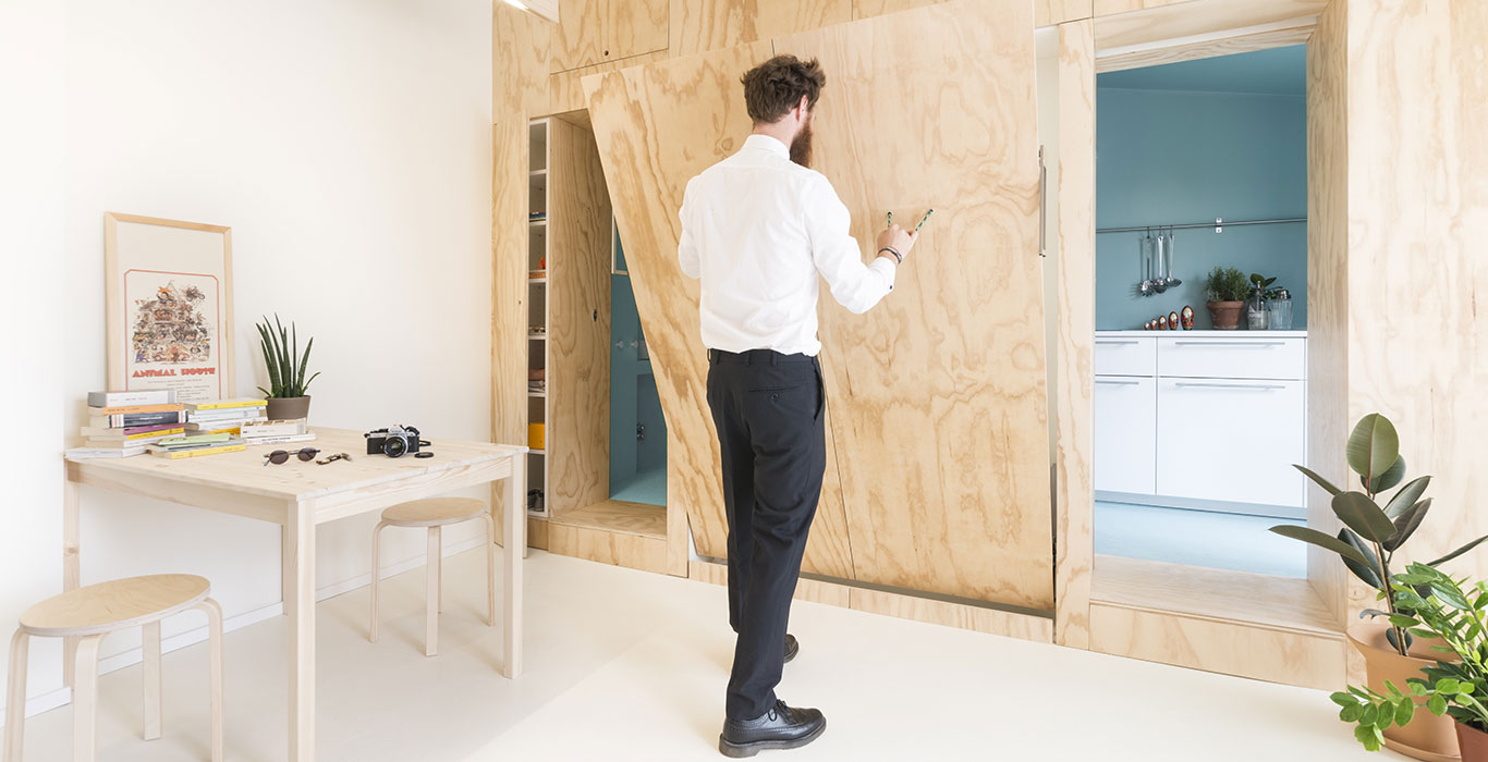 Small 28 square meter apartment in Milan gets modern remodeling which includes a multifunctional furniture piece that hides floating double bed & hides bathroom and kitchen