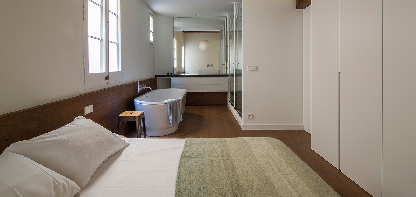 Bathtub in the corner of a modern bedroom - stunning apartment in Barcelona by Nook Architects