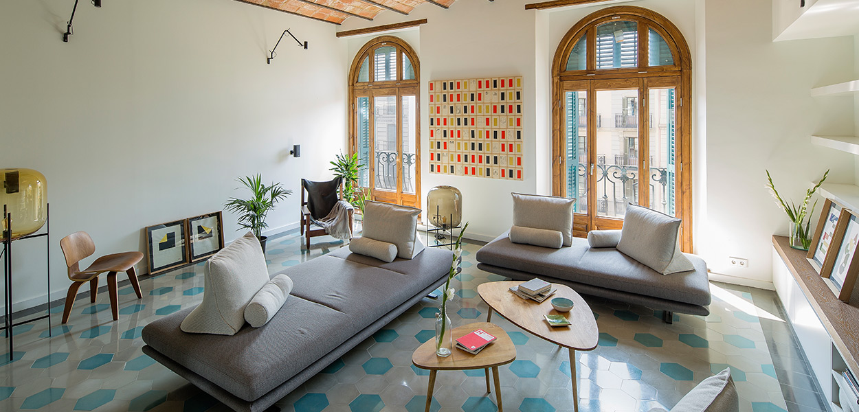 Bright, stylish living room design idea in a stunning apartment in Barcelona that uses mirrors to amplify space and light - designed by Nook Architects