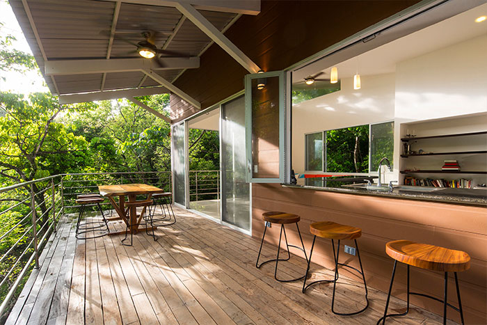 Beautiful terrace of a suspended Costa Rican house that blends with the dense forest - by Indigo Arquitectura