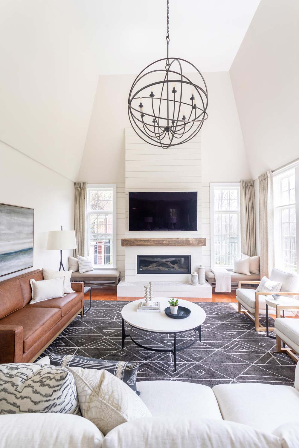 Bright Transitional Family Room with Shiplap Fireplace, Vaulted Ceilings and Large Ceiling Light