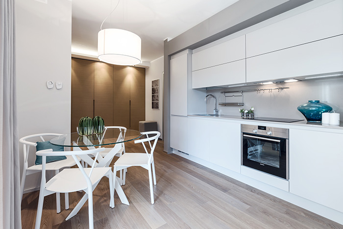 White modern kitchen and dining area in a luxurious Monaco apartment where guests can relax - summer retreat designed by NG-Studio